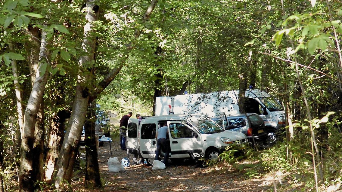 Die Polizei untersucht das Waldstück, in dem das Waffenlager entdeckt wurde.
