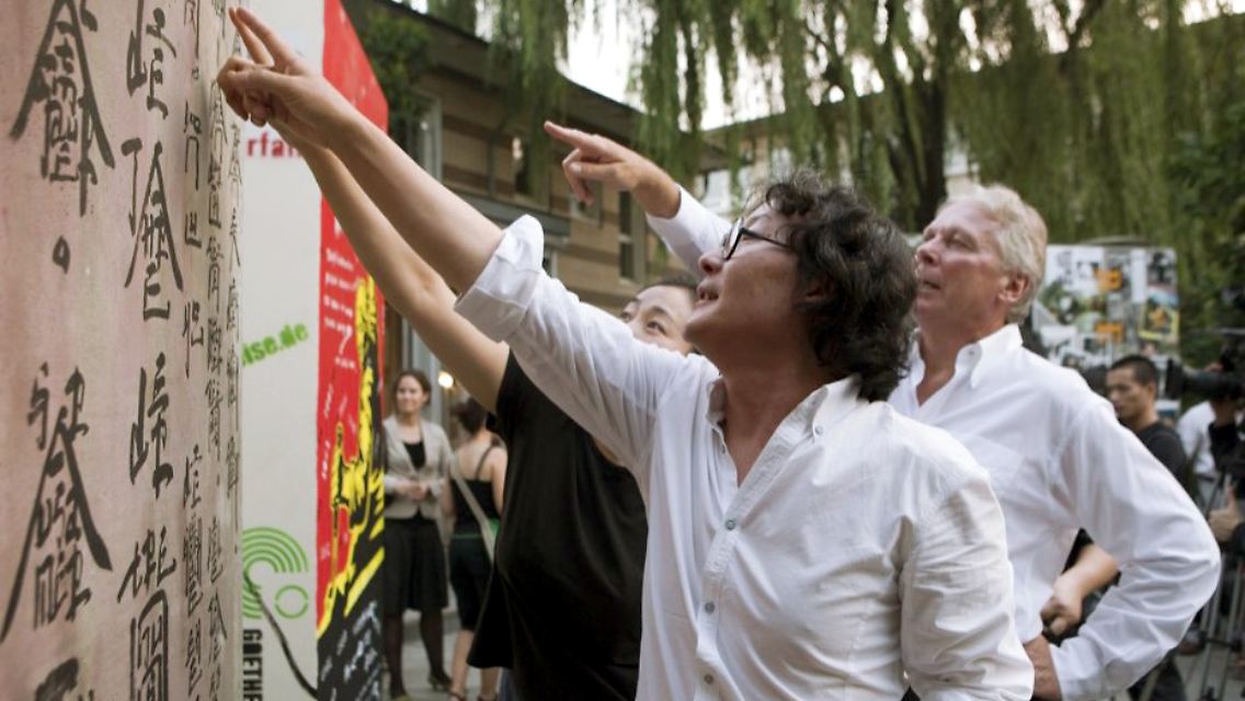 Der chinesische Künstler Xu Bing erklärt dem deutschen Botschafter in Peking, Michael Schaefer, seinen "Mauerstein".
