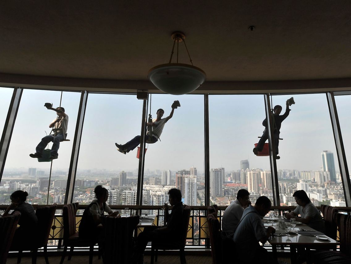 Gebäudereiniger bei der Arbeit hoch über dem Zentrum von Wuhan: In der Hauptstadt der zentralchinesischen Provinz Hubei leben mehr als vier Millionen Menschen.