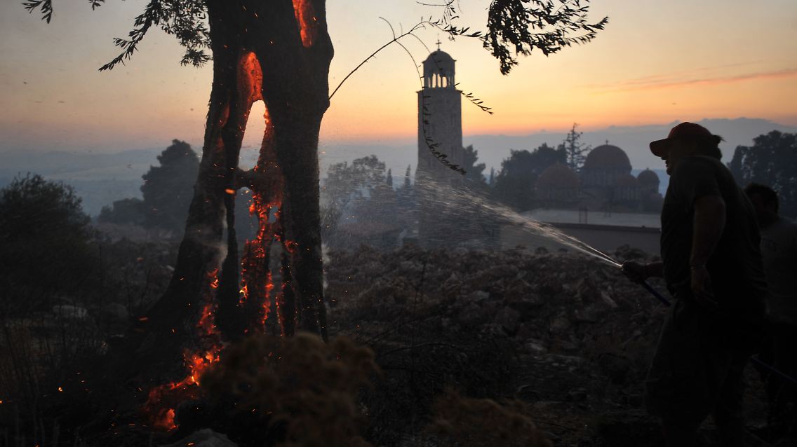 Ein Mitglied der Freiwilligen Feuerwehr vor einem Kloster in Nea Makri nördlich von Athen. Das Kloster wurde am Montag evakuiert.