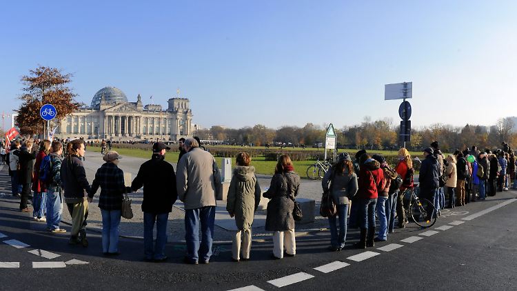 Kapitalismus-Gegner in Berlin formieren sich zu einer Menschenkette.