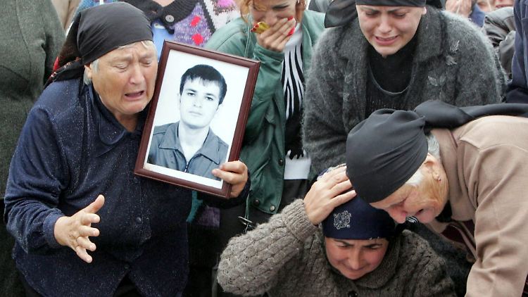 Angehörige während der Beerdigung der Opfer des Geiseldramas weinen am Sarg von Albert Baniyev. (Archivbild von 2004)