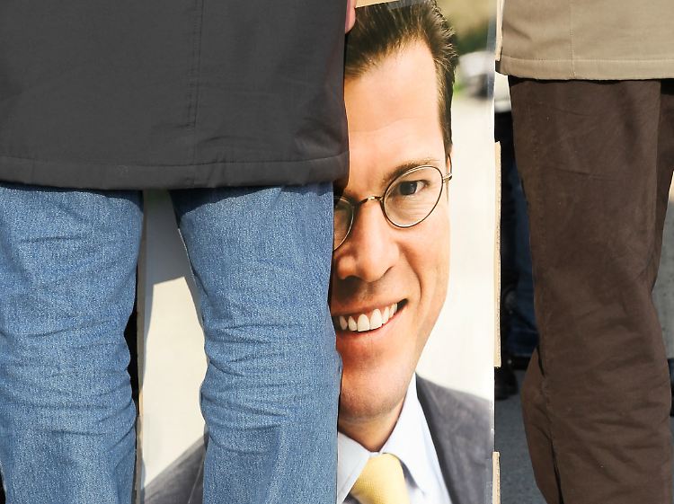Ein Guttenberg-Anhänger hält beim Politischen Aschermittwoch ein Plakat von "KT".