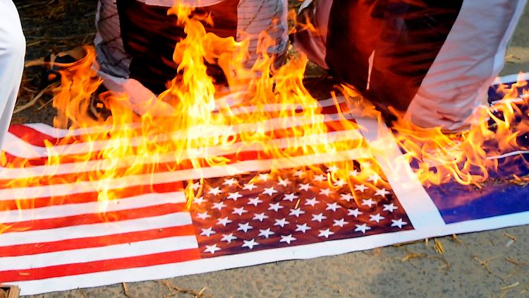 Pakistani verbrennen US-Flaggen als Zeichen des Protests.