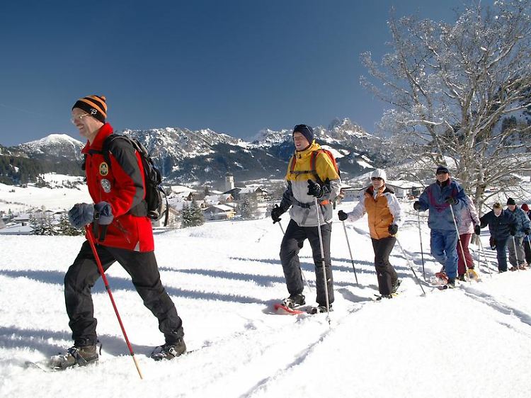 Schuh ganz anheben, vorwärts bewegen und nicht abrollen: Gästeführer Rief (l.) bringt Urlaubern im Tannheimer Tal das Schneeschuhwandern bei.