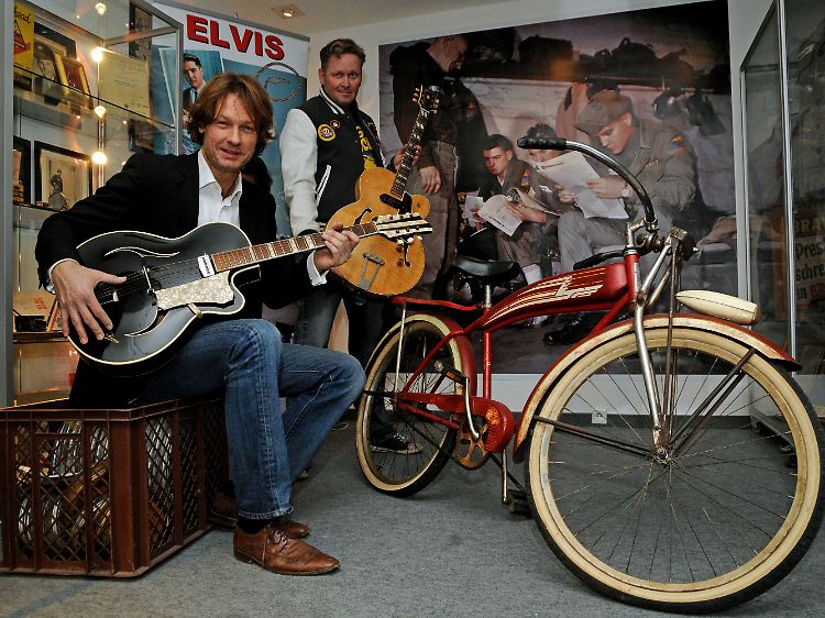 Die Sammler Torsten Meck (l) und Andreas Schröer mit Gitarren von Elvis und einem Fahrrad, das er als Teenager hatte.