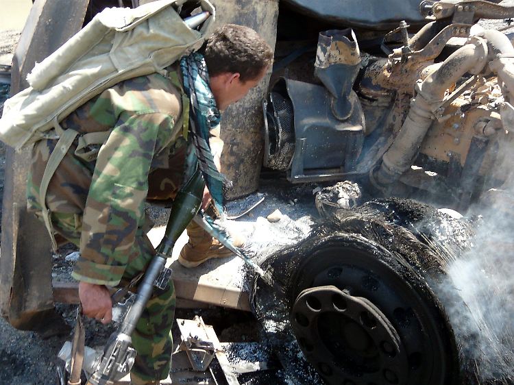 Ein Soldat inspiziert einen der ausgebrannten Tanker.