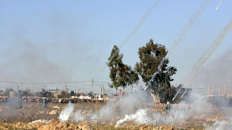 Israelische Soldaten beschießen palästinensische Demonstranten in der Westbank mit Tränengas.