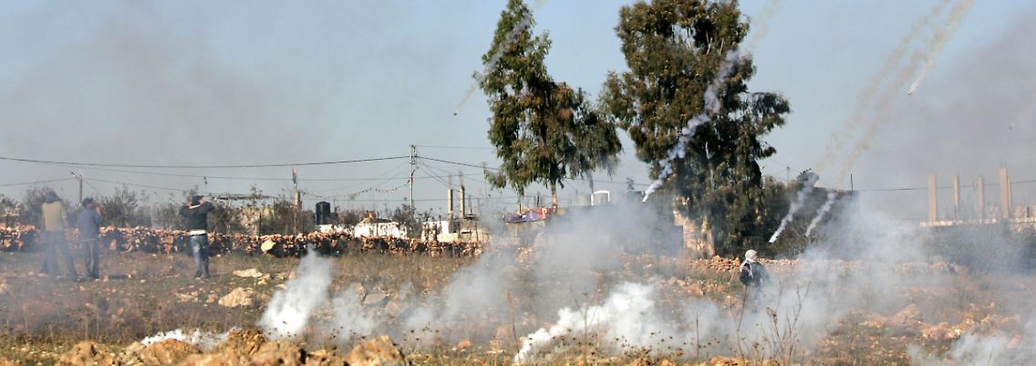 Israelische Soldaten beschießen palästinensische Demonstranten in der Westbank mit Tränengas.