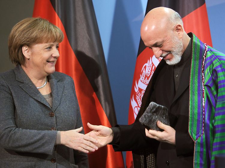 Für Merkel nimmt Karsai sogar sein Hütchen ab.