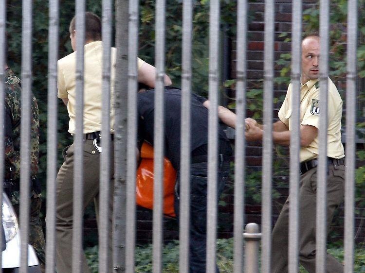 Polizisten führen eine Demonstranten ab, der die Feier stören wollte.