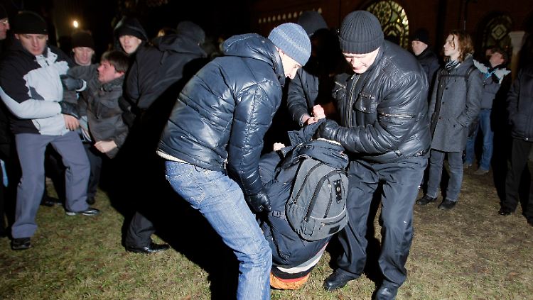 Sicherheitskräfte schleppen Demonstranten weg.