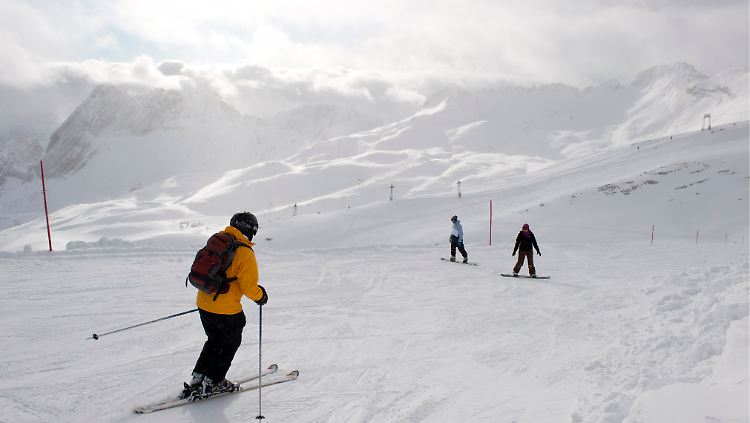 Skifahrer und Snowboarder fahren auf der Zugspitze bei Grainau die Piste hinab.