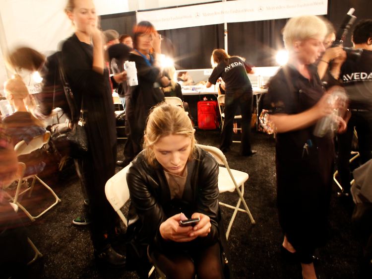 Mobil in den USA: Eine mögliche Kundin bedient bei den Vorbereitungen zur Schau der Frühjahrskollektion 2010 von Christian Siriano während der New York Fashion Week ihr mobiles Endgerät.