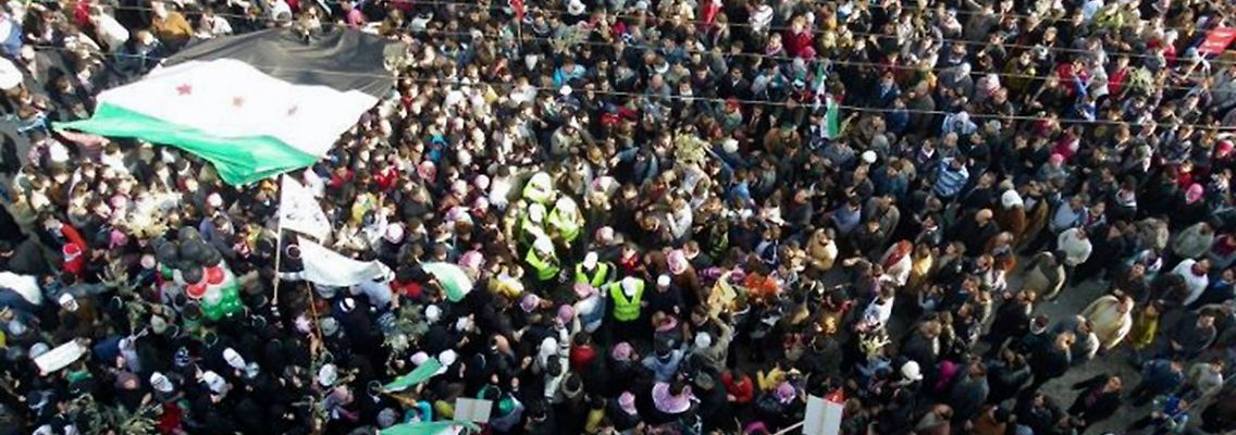 Die Beobachter der Arabischen Liga inmitten der Demonstranten (Männer mit gelben Westen, Bildmitte).