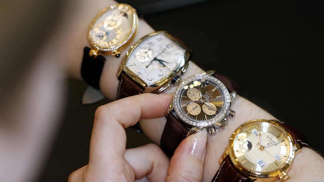 Eine Verkäuferin präsentiert verschiedene Uhren von Swatch.