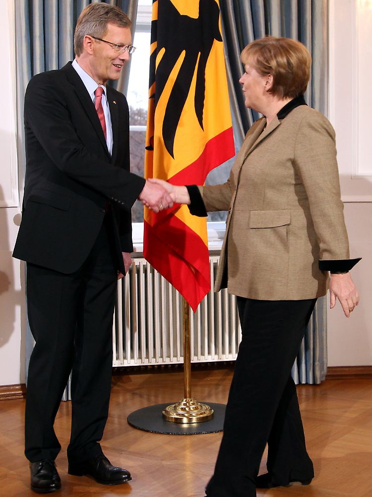 Die Kanzlerin reicht Wulff die Hand beim Neujahrsempfang.