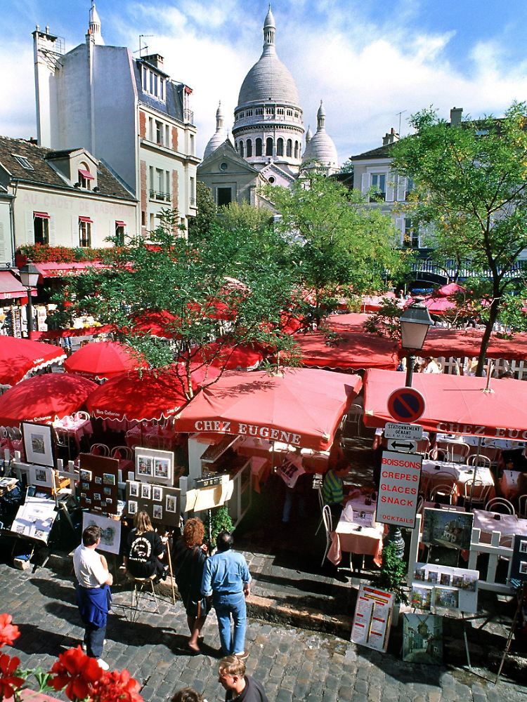 Rote Sonnenschirme der Lokale und Kunststände auf dem Place du Tertre im Pariser Künstlerviertel Montmartre.