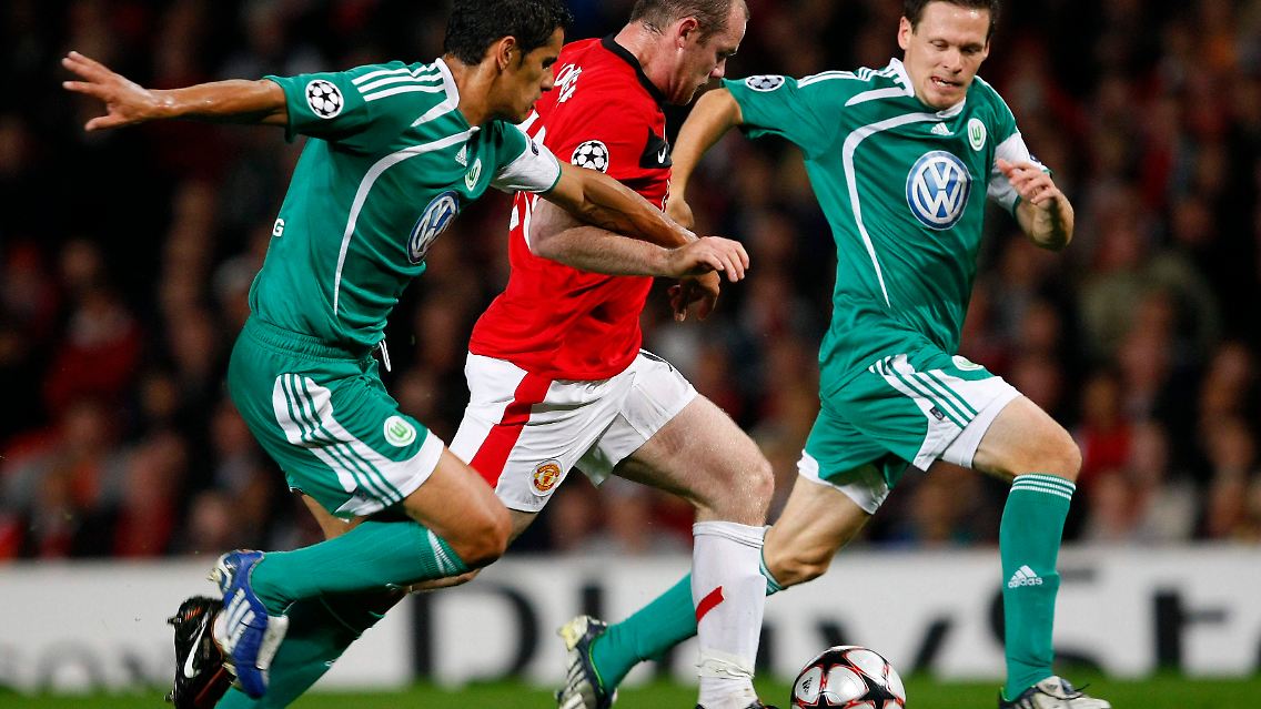 Einen Schritt schneller: Manchesters Wayne Rooney enteilt zwei Wolfsburger Spielern.