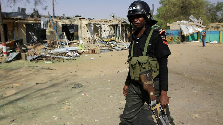 Ein Polizeioffizier läuft durch die Straßen von Kano.