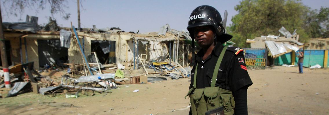 Ein Polizeioffizier läuft durch die Straßen von Kano.
