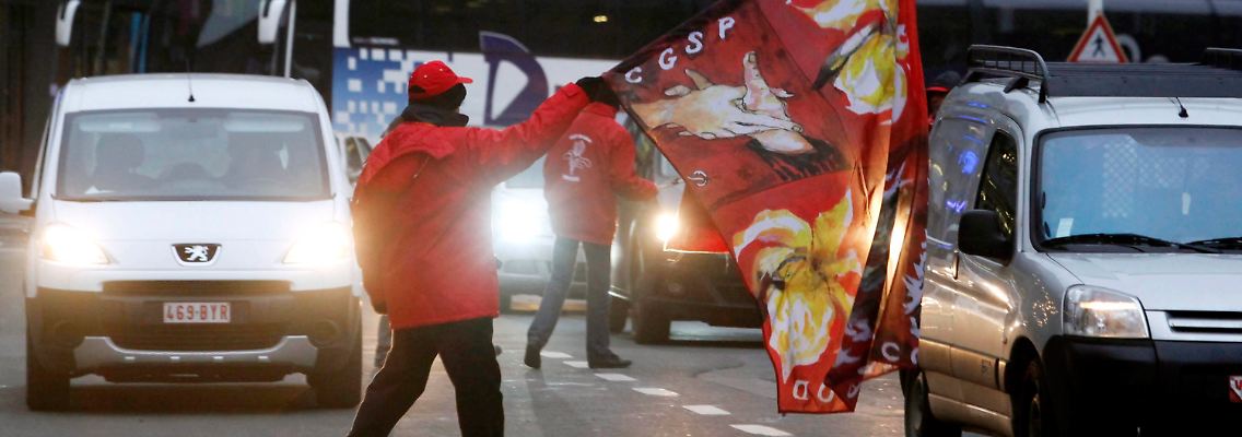Ein Streikender blockiert eine Straße in Brüssel.