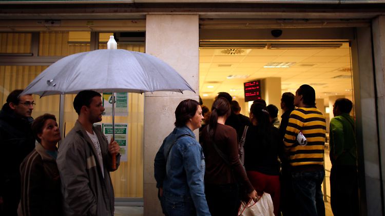 Arbeitslose warten im spanischen Malaga vor einem Arbeitsamt.