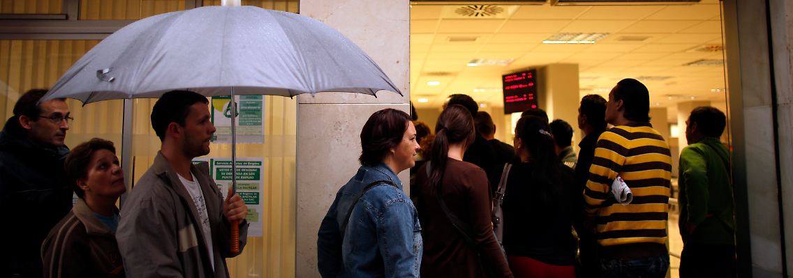 Arbeitslose warten im spanischen Malaga vor einem Arbeitsamt.