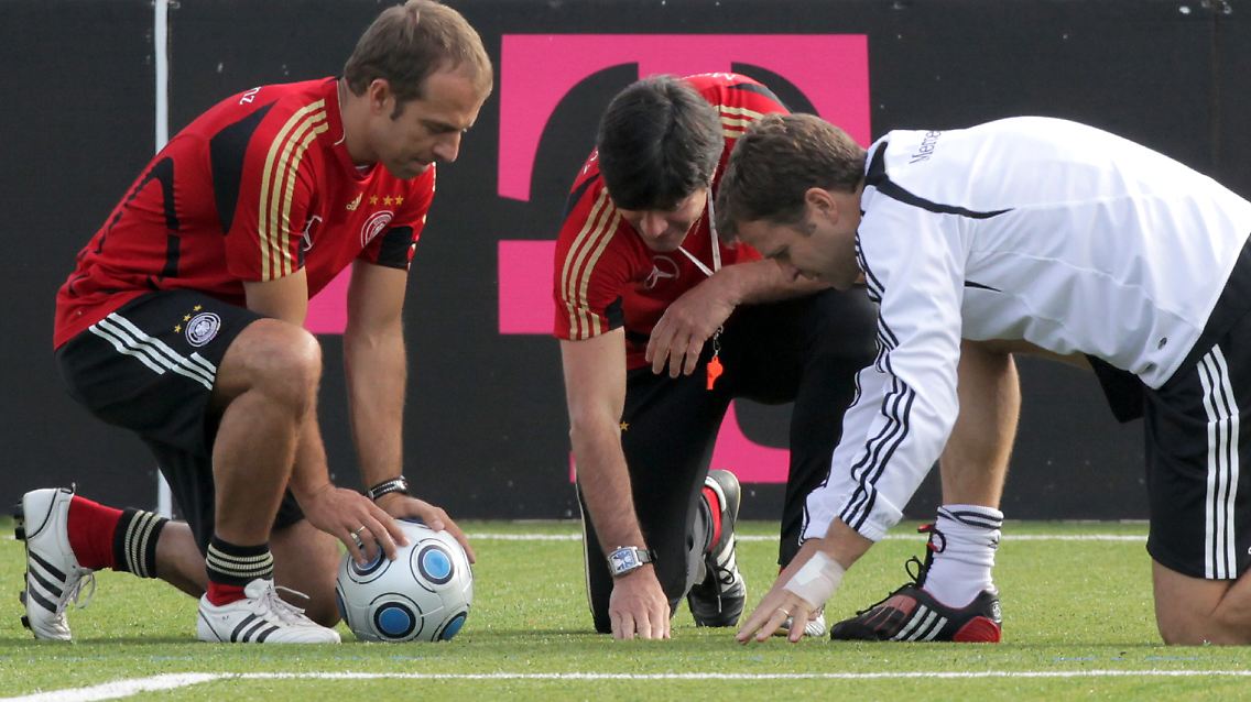 Kunst auf Rasen? Am Samstag spielt die deutsche Fußball-Nationalmannschaft in Moskau - auf Kunstrasen. Bundestrainer Jochim Löw, Co-Trainer Hansi Flick, links, und Manager Oliver Bierhoff sehen sich die Plastikhalme ganz genau an.