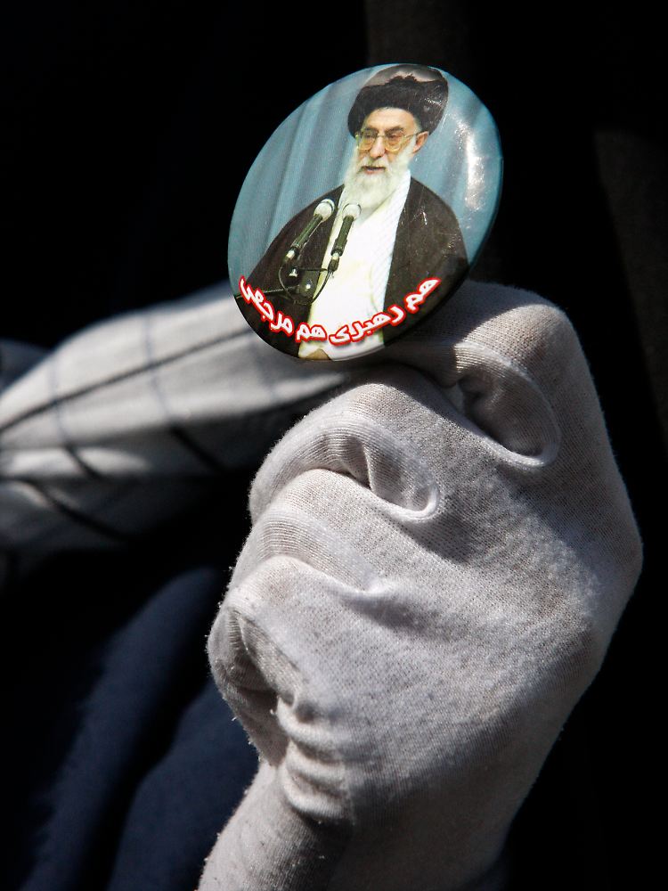 Eine Frau zeigt das Bild des Obersten Führer der Islamischen Republik, Ajatollah Ali Chamenei.