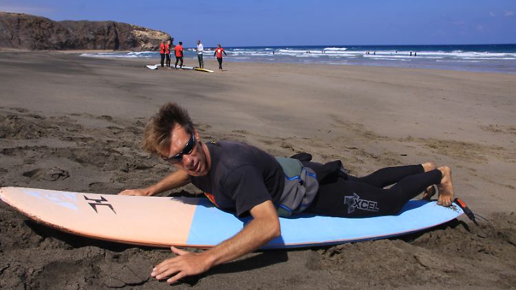Trockenübung: Am Strand der Jandia-Halbinsel zeigt Surflehrer Francis Suber, wie man anpaddelt und auf das Brett aufspringt.
