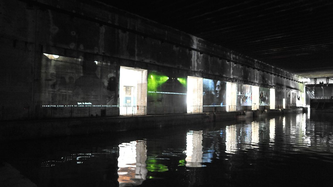 Eine Installation des Filmregisseurs Amos Gitai wirft Szenen aus seinen Filmen an die Wände des U-Boot Bunkers in Bordeaux.