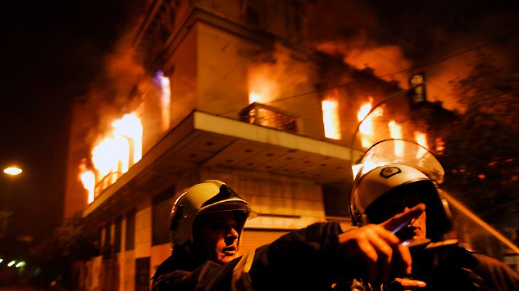 Feuerwehrleute vor einem brennenden Gebäude in Athen.