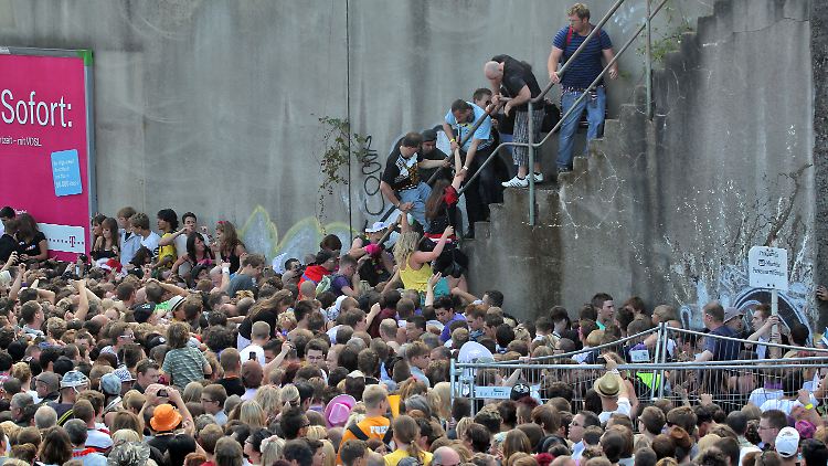 Die Menschen stehen dicht gedrängt an einem Tunnelausgang in Duisburg.