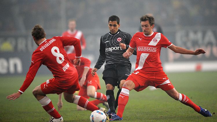 Düsseldorfs Sascha Dum (l.) und Adam Bodzek (r.) kämpfen mit Frankfurts Karim Matmour um den Ball. 