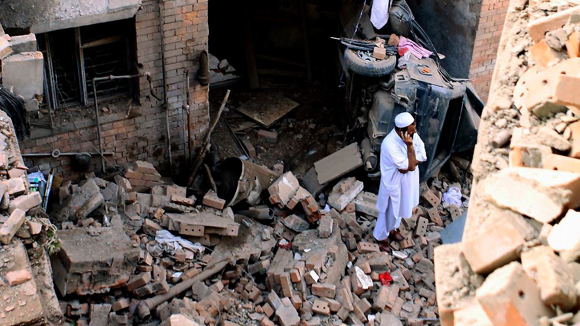 Ein Mann steht vor den Trümmern eines Hauses in Peshawar.