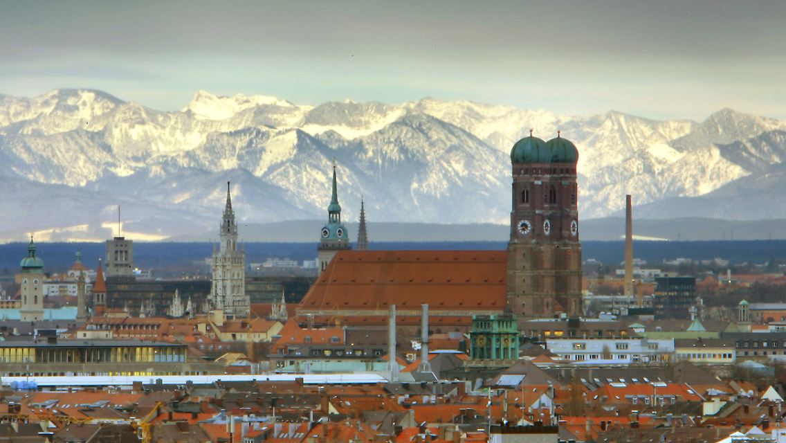 Kann dieses Panorama das IOC überzeugen? Die Frauenkirche vor den schneebedeckten Alpen.
