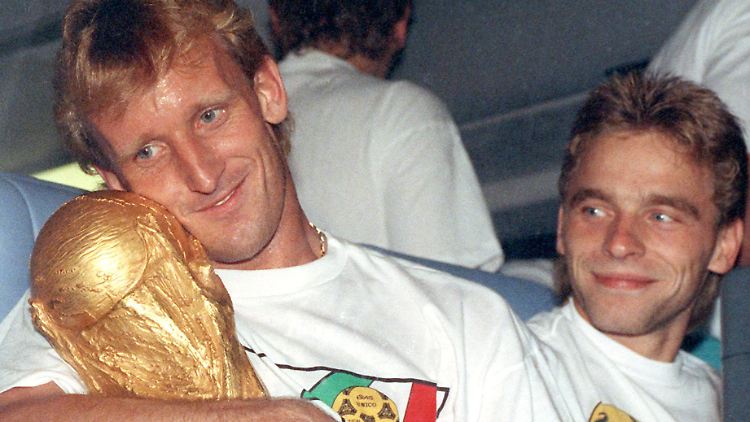 So kennen wir ihn: Andreas Brehme schmust 1990 mit dem Weltmeisterpokal. Der Kleine rechts, das ist Thomas Häßler.