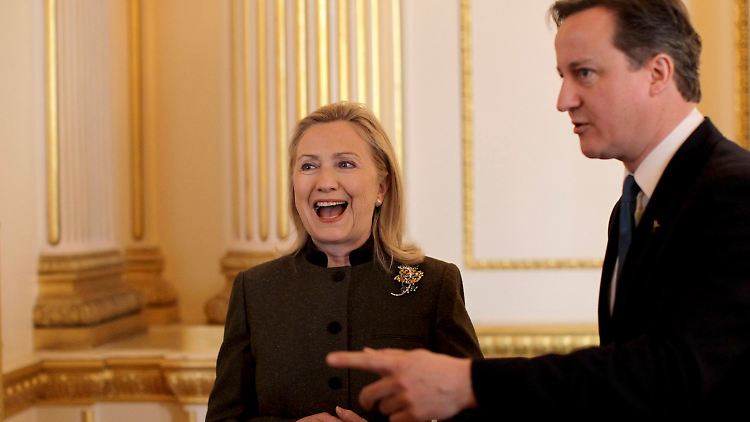 Der britische Premierminister David Cameron zeigt US-Außenministerin Hillary Clinton den Weg.