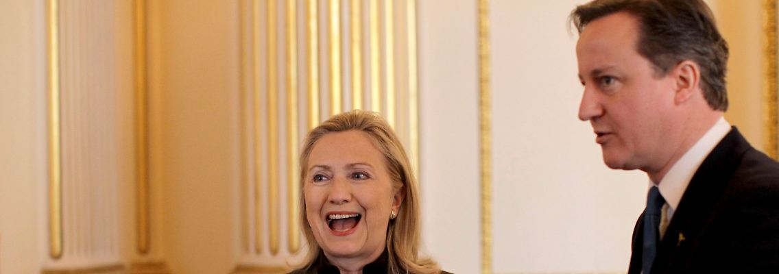 Der britische Premierminister David Cameron zeigt US-Außenministerin Hillary Clinton den Weg.