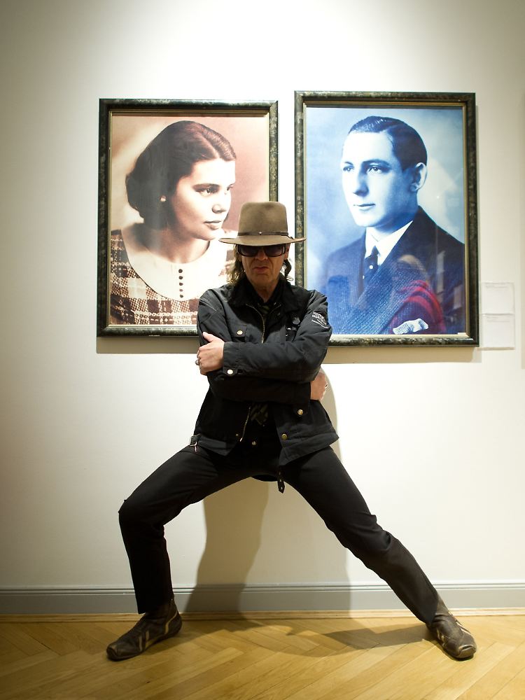 Udo Lindenberg posiert im Museum für Kunst und Gewerbe in Hamburg vor den Bildern seiner Eltern.
