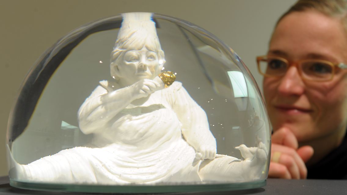 Die junge Designerin Marianne Eggimann betrachtet in Leipzig eine ihrer Arbeiten.