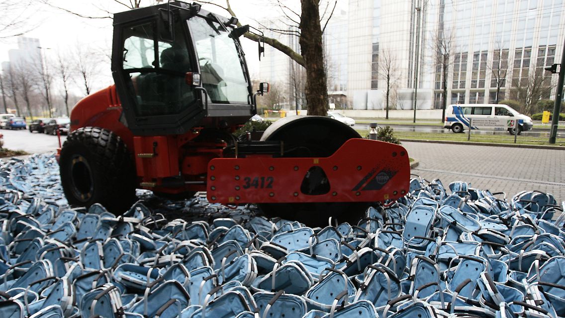 Eine Walze plättet vor dem Wirtschaftsministerium in Düsseldorf Plagiate eines Einkaufskorbes.