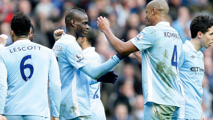 Die Entscheidung: Die Kolllegen von Manchester City gratulieren Mario Balotelli nach seinem Tor zum 2:0.