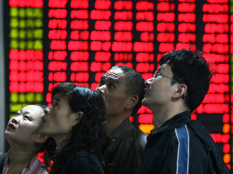 Investoren blicken im chinesischen Fuyang auf Börsenkurse.