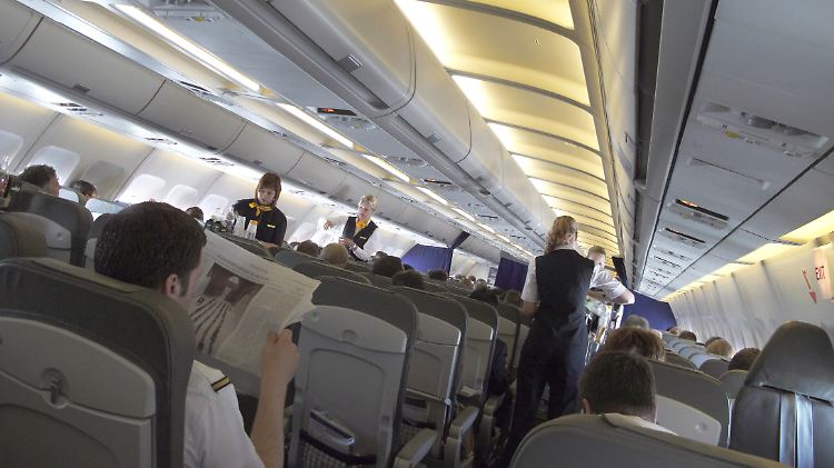 Flugbegleiterinnen beim Verteilen von Getränken.