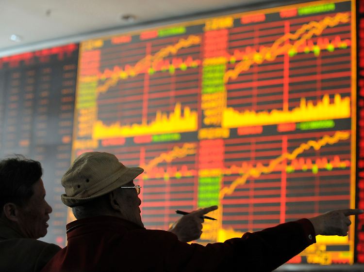 Vor der Kurstafel eines Brokers in Wuhan staunen Anleger über den stärksten Kursanstieg des Shanghai Composite Index binnen eines Tages seit drei Monaten.