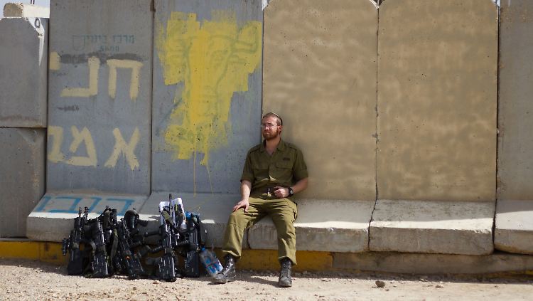 Ein israelischer Soldat sitzt an der Grenze zum Gaza-Streifen.