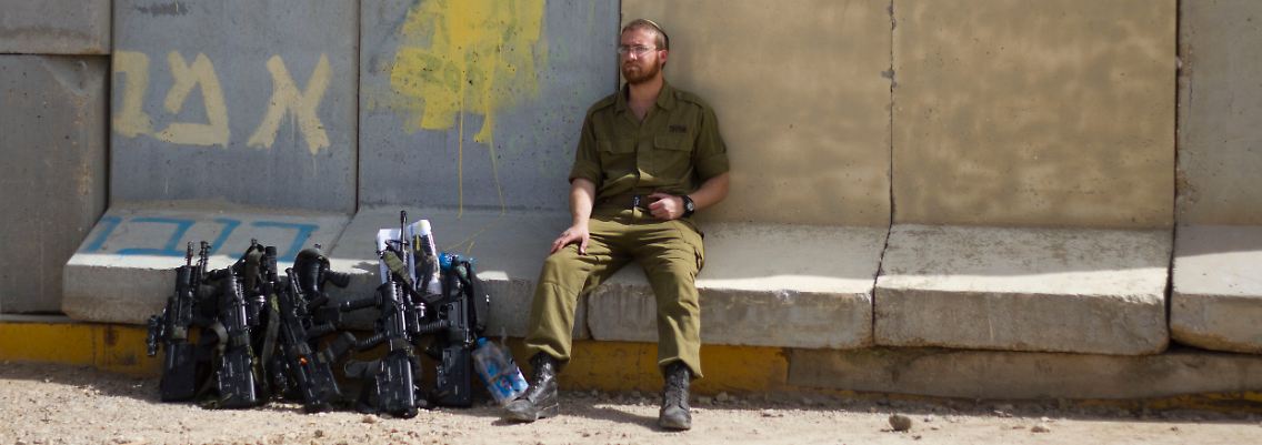 Ein israelischer Soldat sitzt an der Grenze zum Gaza-Streifen.