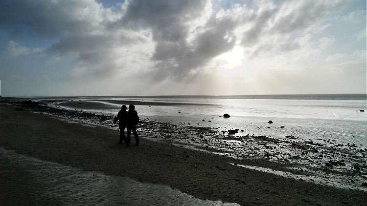 Spaziergänger am Strand bei Hedehusum auf Föhr.